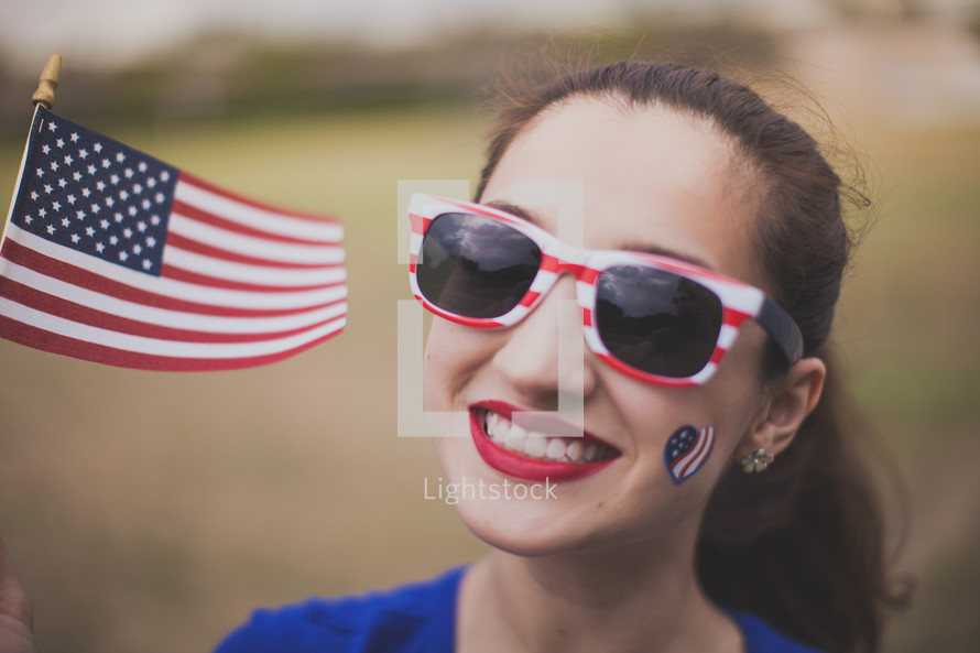woman wearing stars and stripes sunglasses and a temporary tattoo
