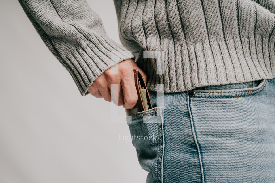a man tucking his wallet into his back pocket 
