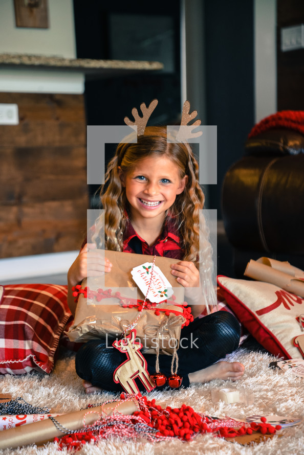 smiling little girl holding a Christmas present 