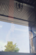 Two smiling young women reflected in a window pane.