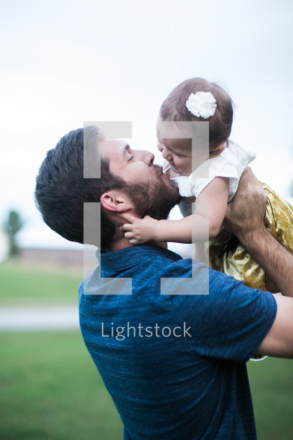 father kissing his toddler daughter 