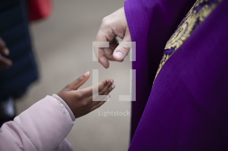 priest shaking a child's hand 