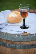 Bread and wine on a wood barrel.