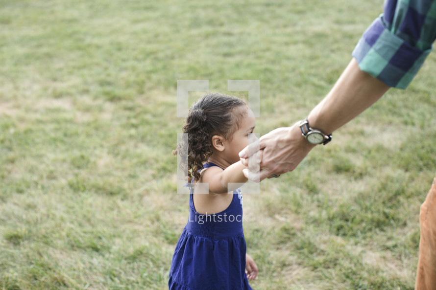 father and daughter holding hands outdoors