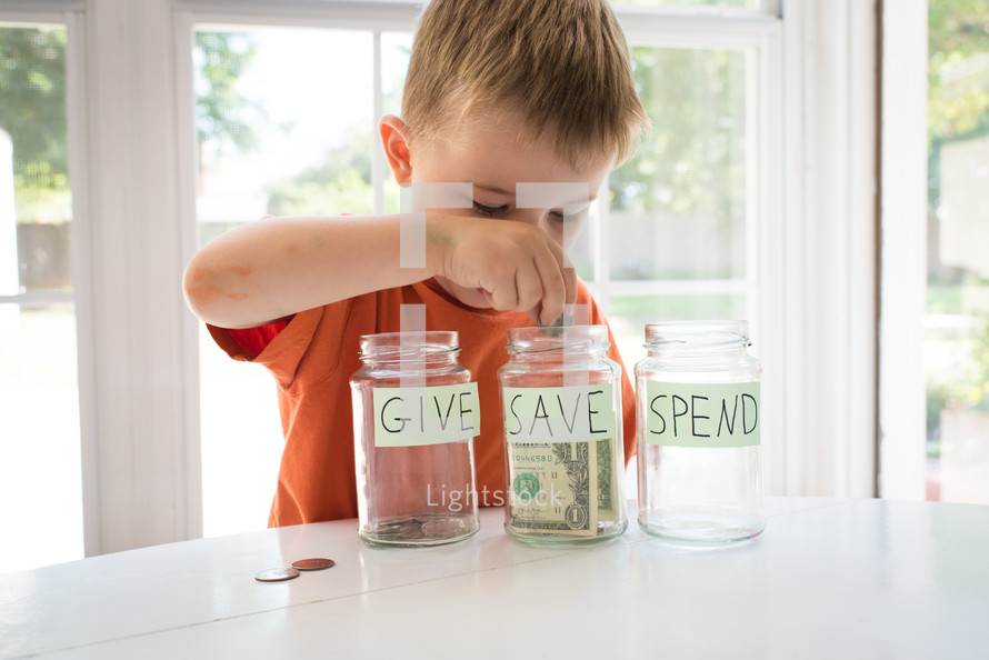 a toddler boy and give, save, spend jars 