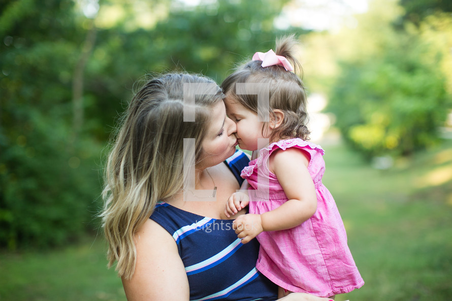 mother kissing her toddler daughter 