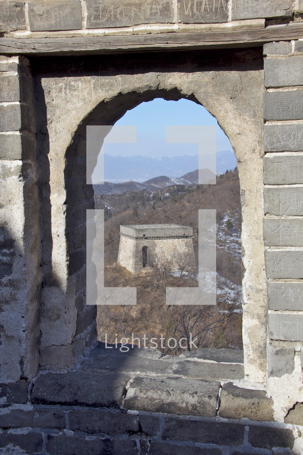 Chinese mountainside seen through an arched window at the Great Wall of China