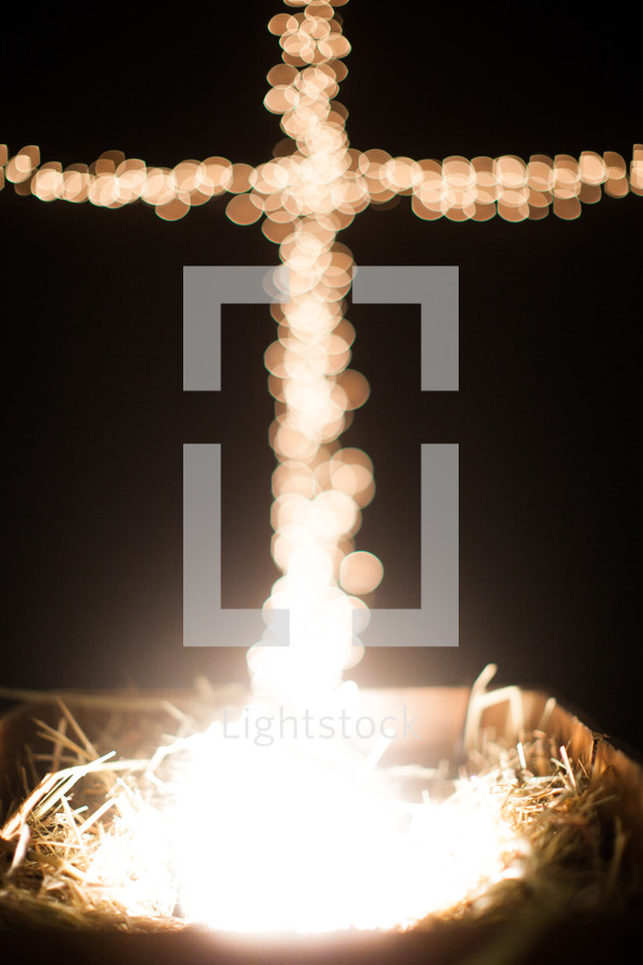 bokeh Christmas lights in the shape of a cross and a manger 