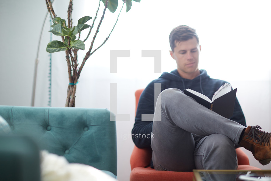 a man sitting reading at home 
