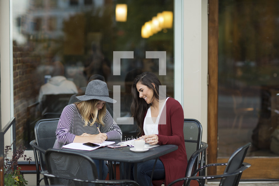 young women reading a Bible and discussing scripture 