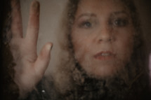 portrait of a woman through mirrored glass