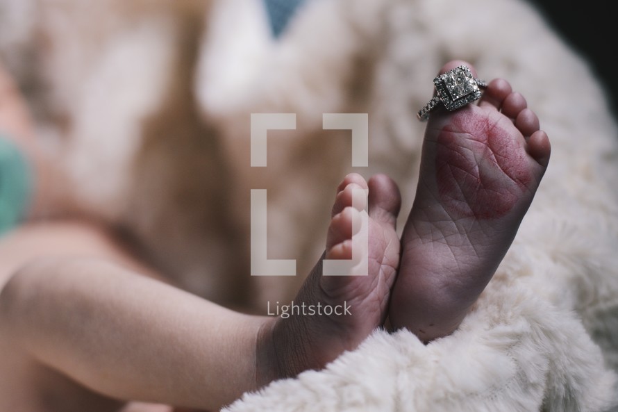 a newborns toes and a diamond ring 