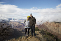 a couple standing together on a mountaintop 