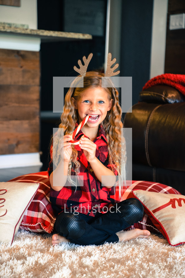 girl child wearing reindeer antlers 