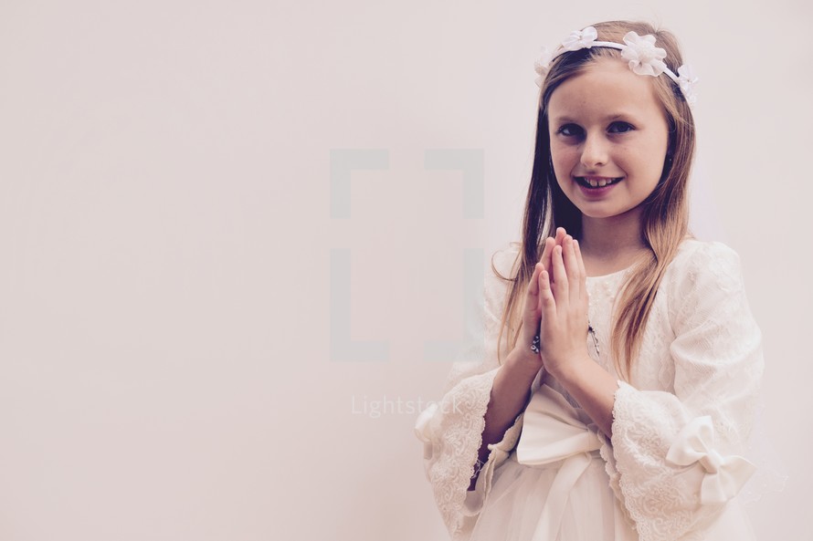 First Communion portrait of a praying little girl 