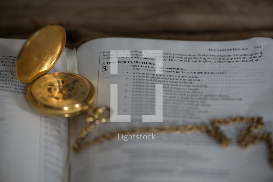 pocket watch on the pages of a Bible 