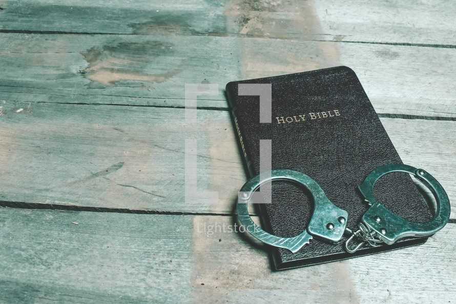 handcuffs on the cover of a Bible 