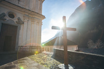 cross in sunlight in front of a church 