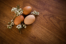 brown eggs and flowers on a wood table 