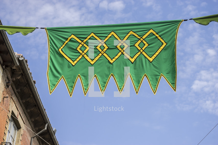 green and yellow banner hanging between buildings 