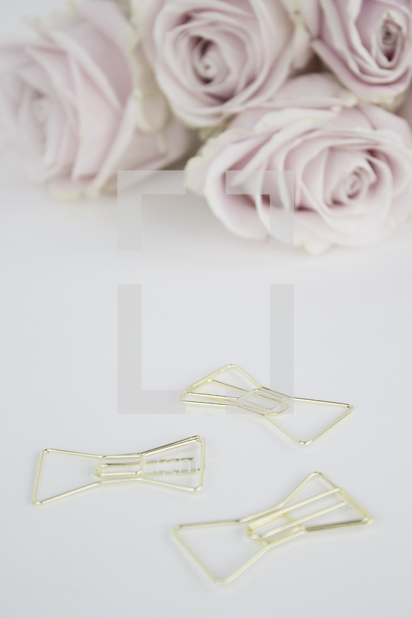pink roses and gold clips on a desk 