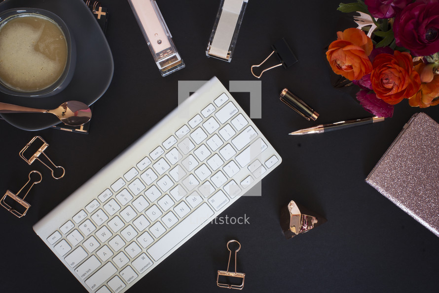 coffee mug, spoon, plate, computer keyboard, border, pen, clips, notebook, notepad, journal, flash drive, paper weight, flowers on a desk 