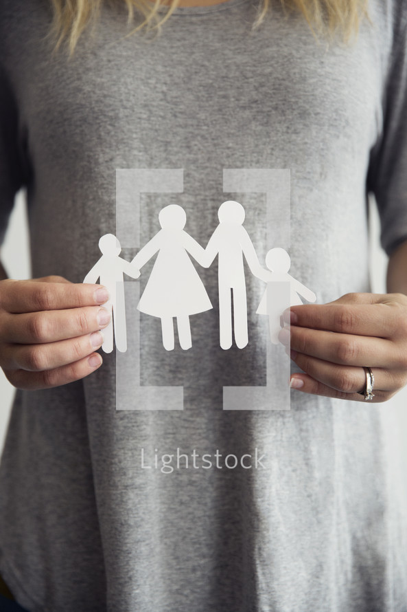 woman holding a paper cutout of a family