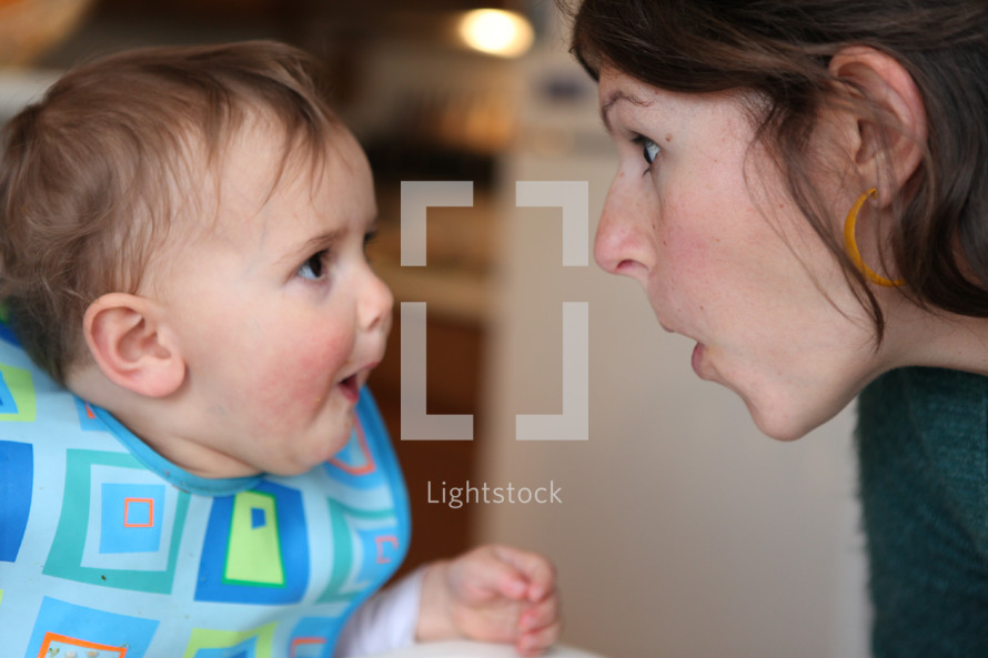 mother and infant son making silly faces 