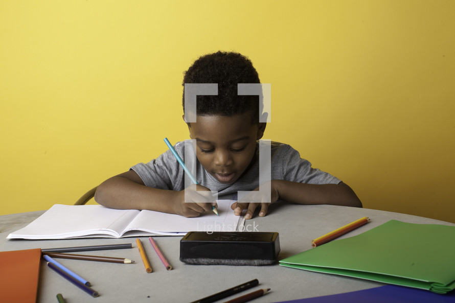 a boy coloring on paper 