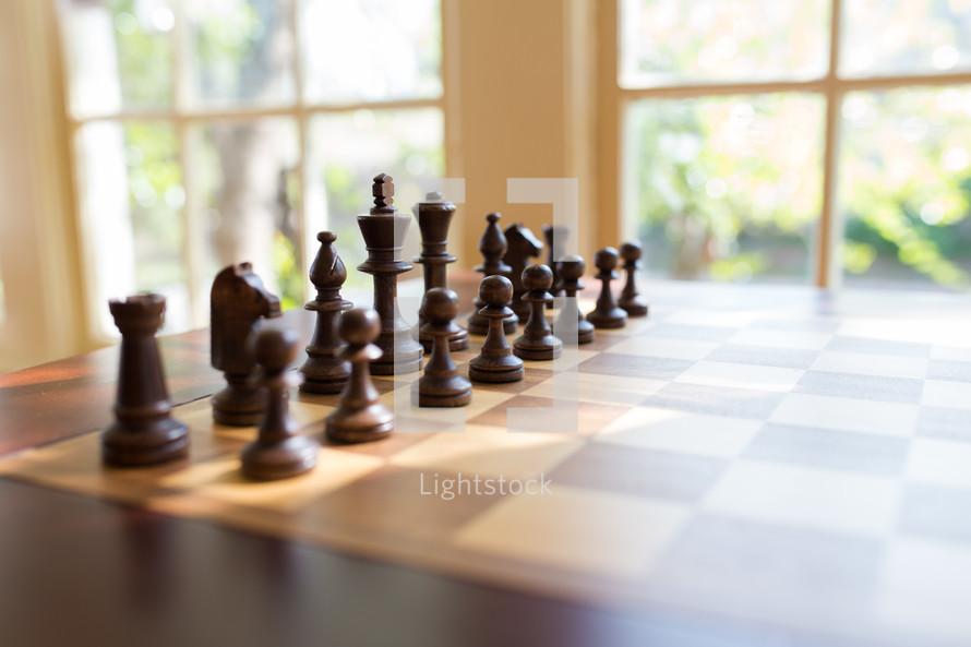 Sunlight through a window onto chess pieces on a chess board.