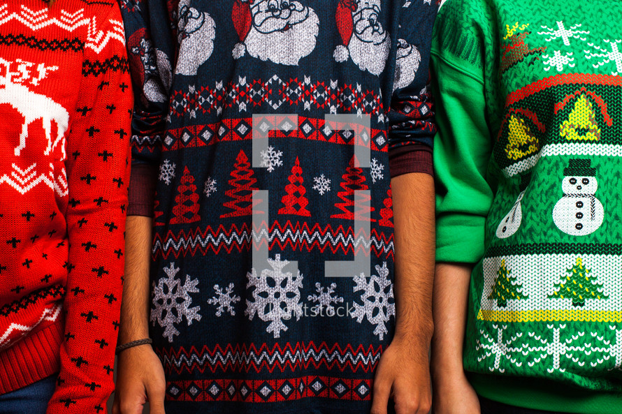 torsos in ugly Christmas sweaters  