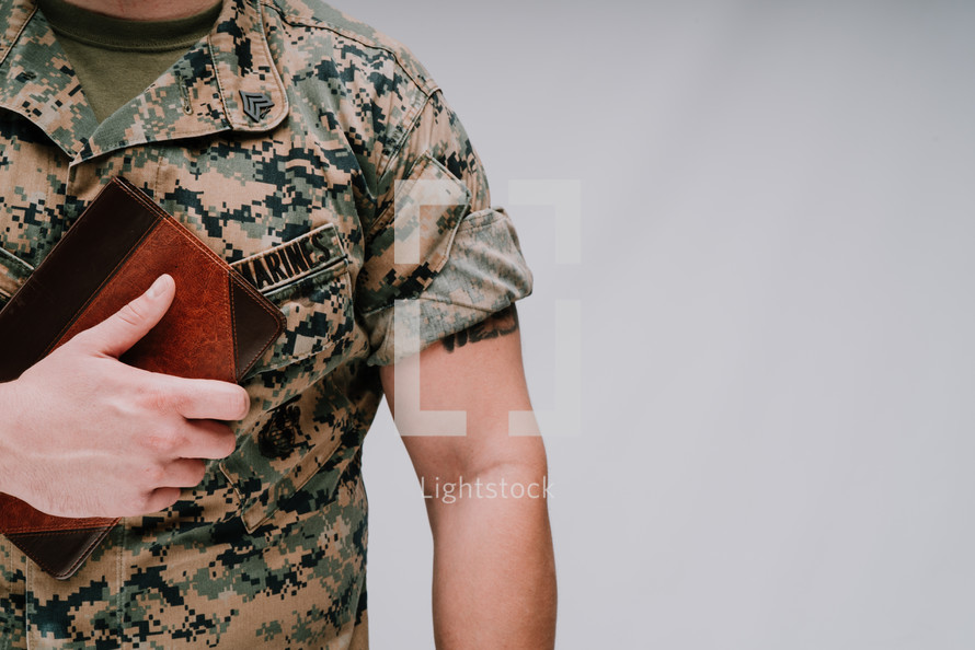 Marine holding a Bible against his chest 