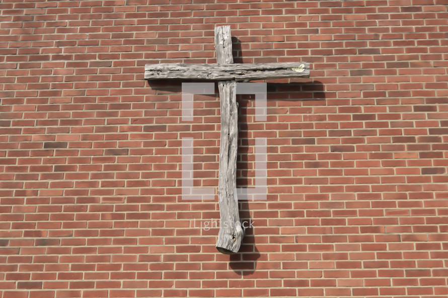 wooden cross on a brick wall 