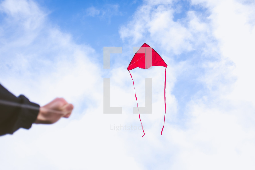 boy flying a red kite 