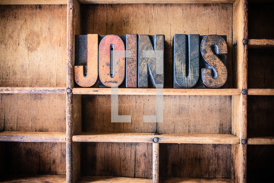 Wooden letters spelling  "join us" on a wooden bookshelf.