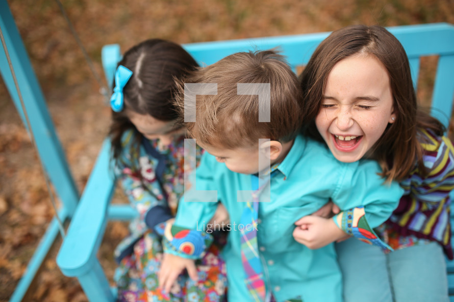 photo of a brother and his sisters laughing 