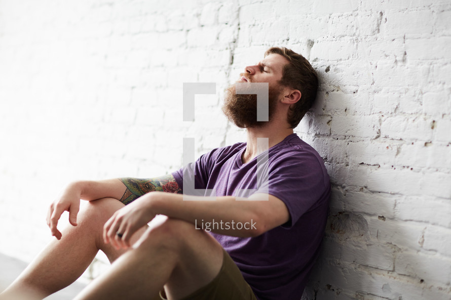 a stressed man sitting alone 