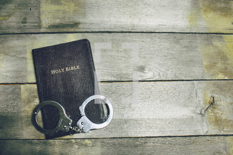handcuff on the cover of a Bible 