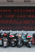 motorcycles parked under Chinese writing 