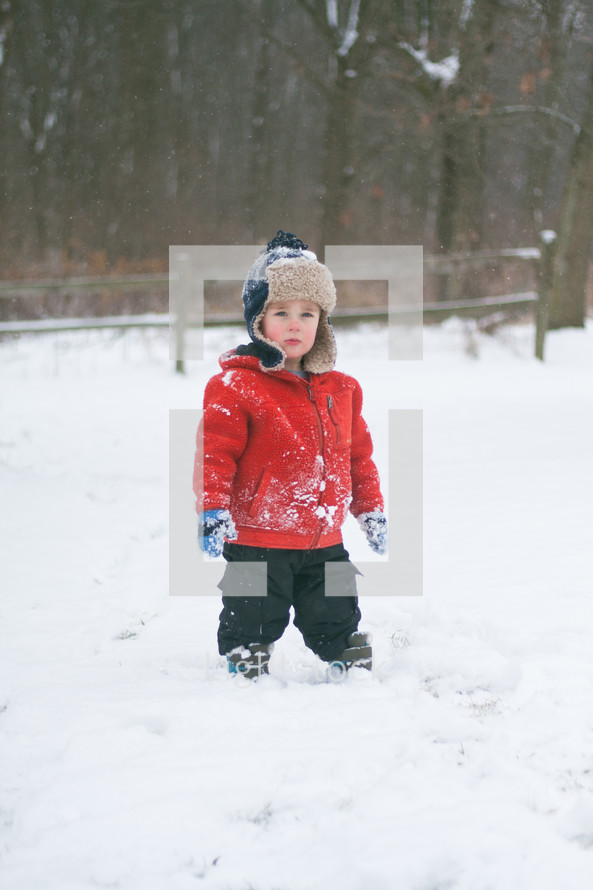 a boy child standing outdoors in snow 