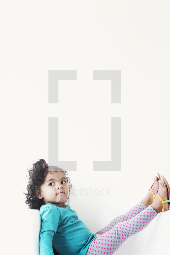 toddler girl with feet in the air 