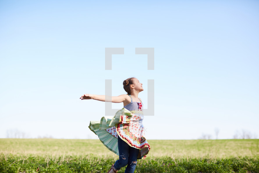 a girl dancing in a field 