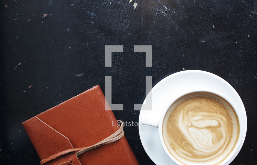 coffee cup and leather bound journal 