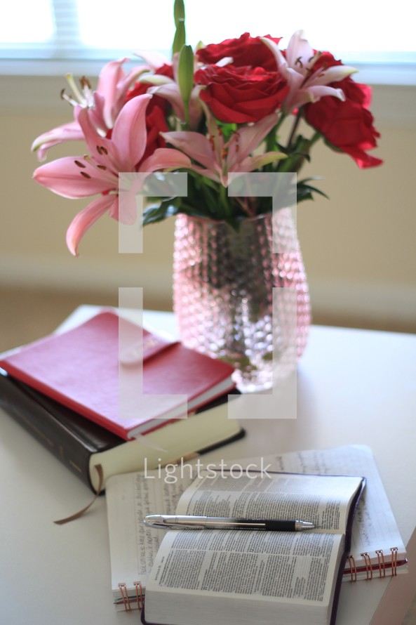 roses and lilies in a vase and notebook and Bible 