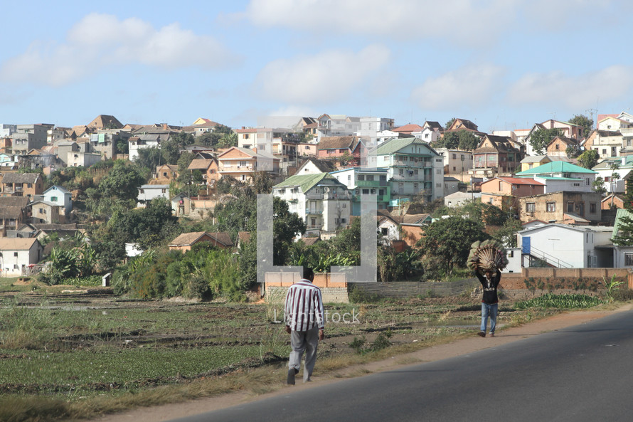 people walking on a street in front of a village 