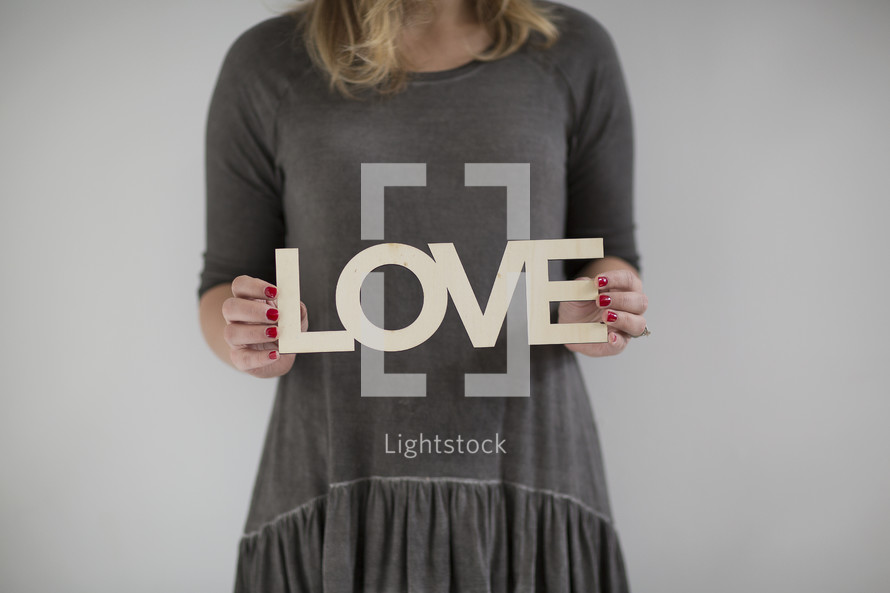 a woman holding a sign of the word love 