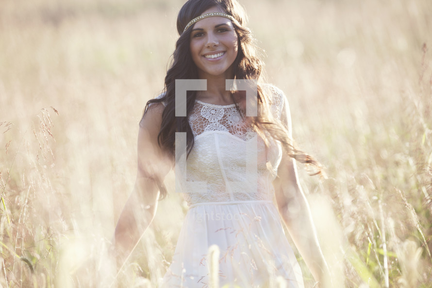Smiling woman in a field of tall grass.