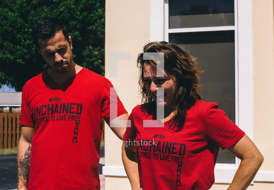 man and woman in red unchained t-shirts 