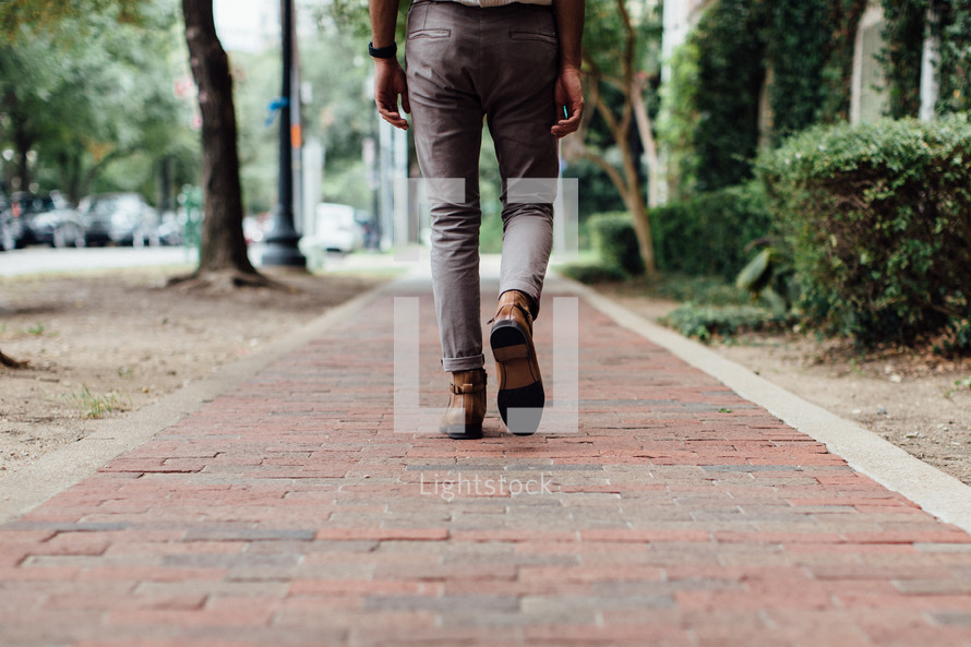 a man walking down a sidewalk 