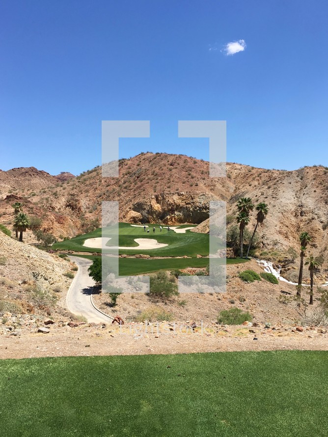 golfers on a golf course surrounded by desert mountains in Nevada 
